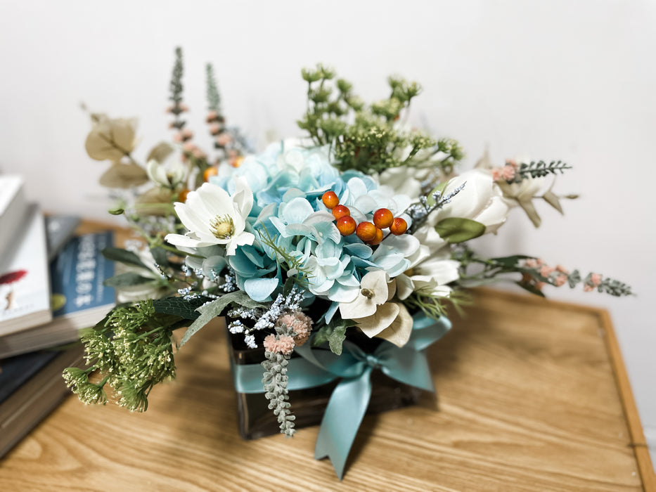 Faux Sky Blue Hydrangeas with Yellow Queen's Anne Lace In A Low, Square Vase